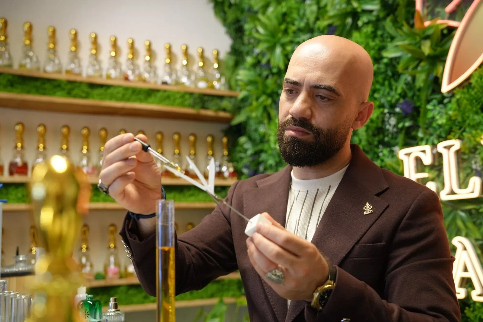 Angelo ruikt aan een geurstrip voor de gouden flessenwand